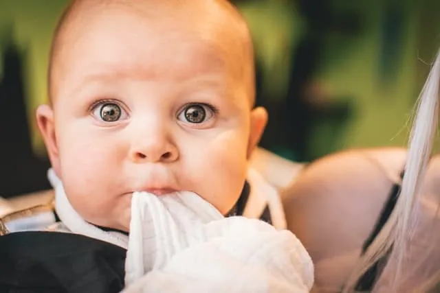 Baby with a shocked look on their face and with wide open eyes