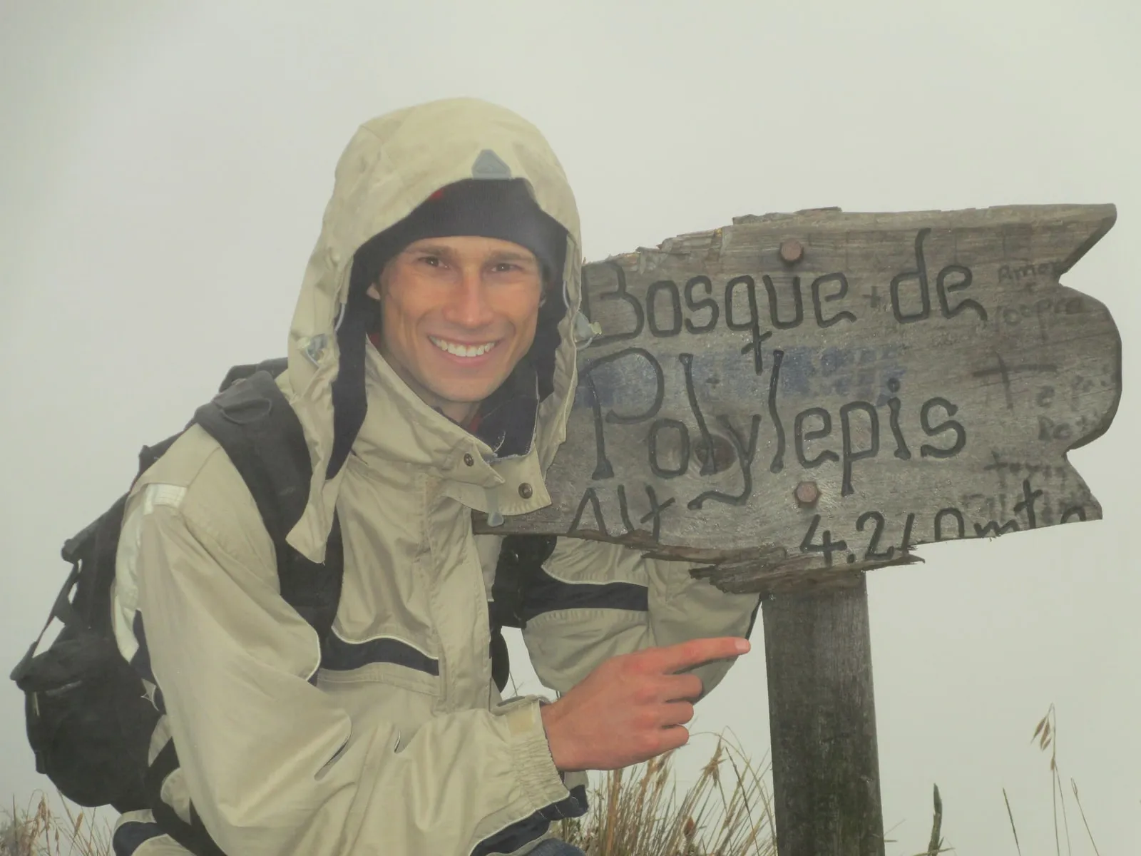 David Nowak beside a trail sign reading 4,260m, in heavy fog