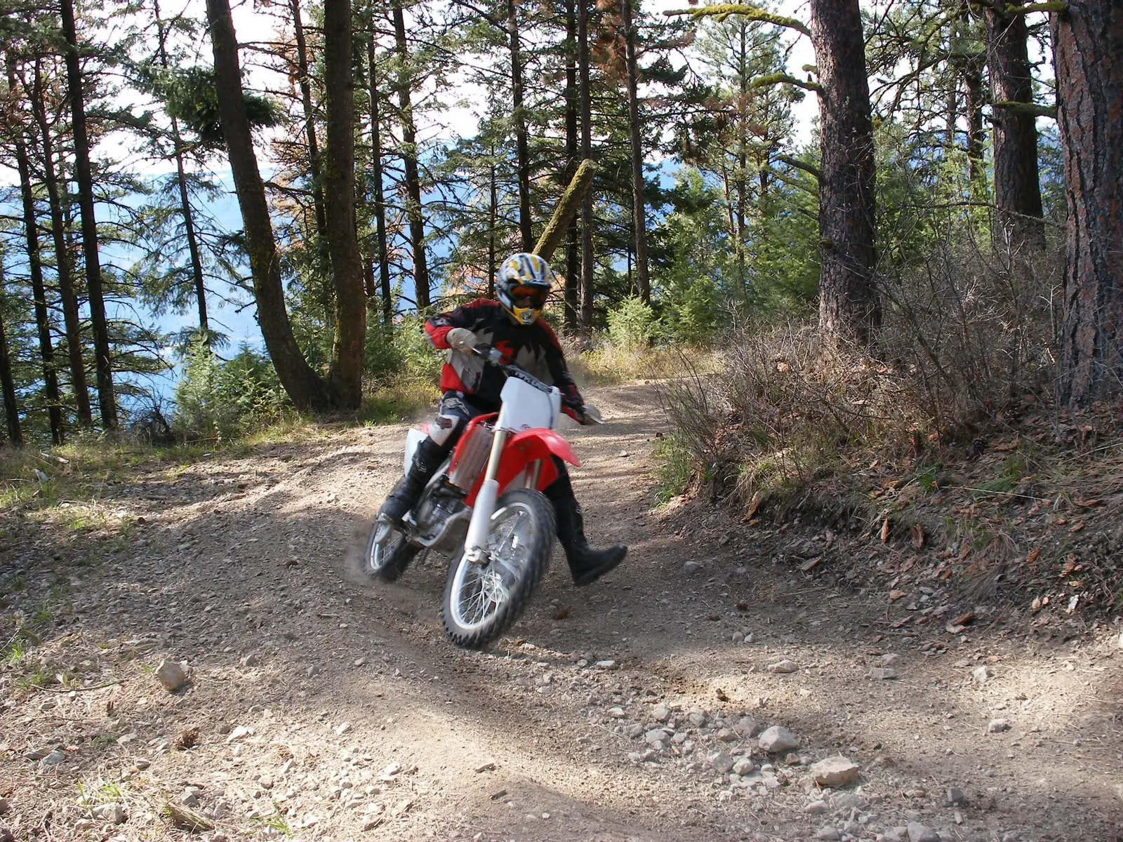 David Nowak riding his motocross bike along a forest trail