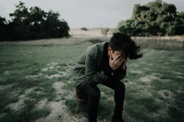 A man realizing he made a stupid mistake and has his hands in his face