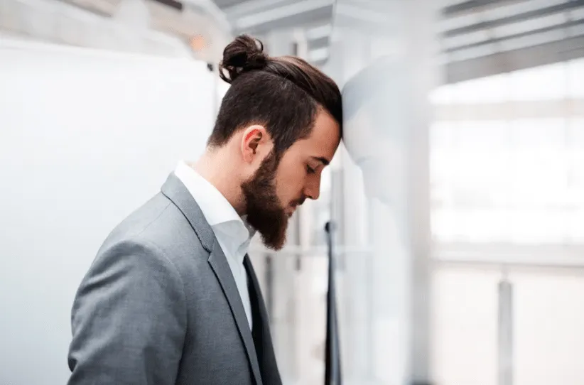 A person banging their head against a wall repeatedly