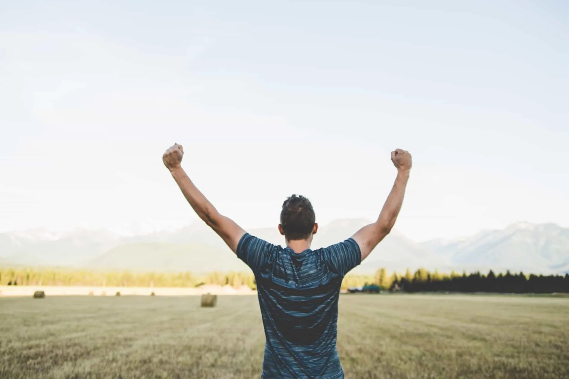 A man standing with his back to the camera and his arms up in the air