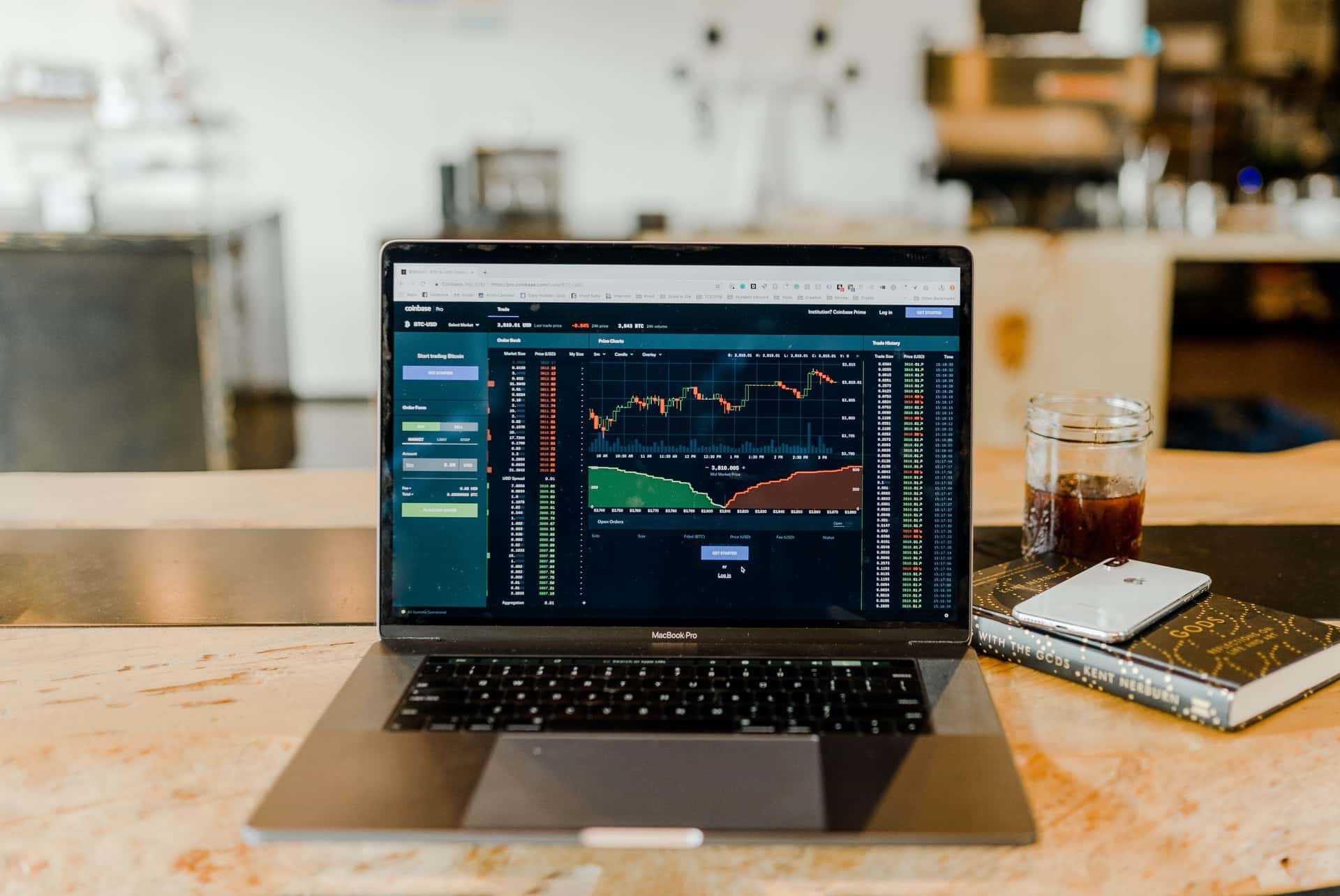 A laptop sitting on a desk with a stock trading chart open