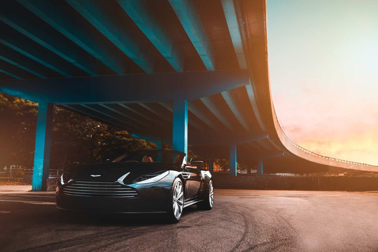 A convertible sports car under a bridge
