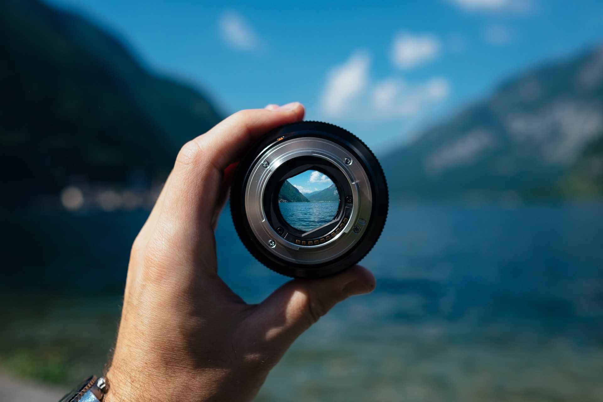 A man holding and looking through a lense off into the distance.