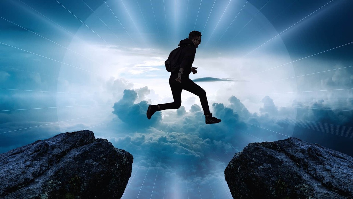 A man jumping from one cliff edge to another